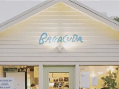 Exterior storefront of Barracuda Taco Stand at 3984 Tchoupitoulas St, New Orleans, a pale yellow gabled building with the hand-painted blue 'Barracuda' sign above the windows