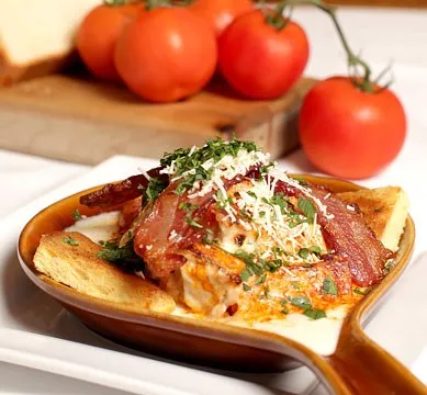 An open-faced Hot Brown sandwich topped with bacon, cheese sauce and Parmesan at The Brown Hotel