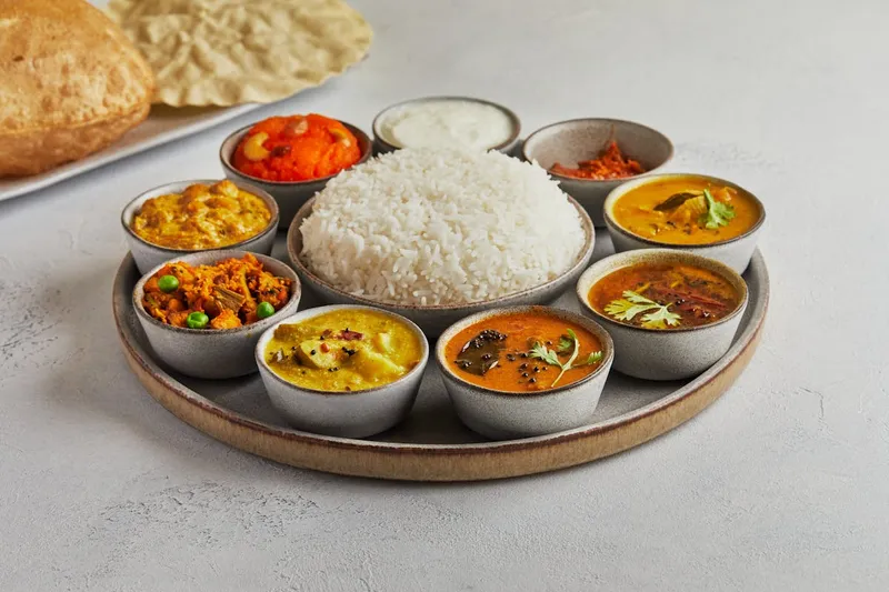 South Indian thali with rice, assorted curries, poori, and papad at Saravanaa Bhavan