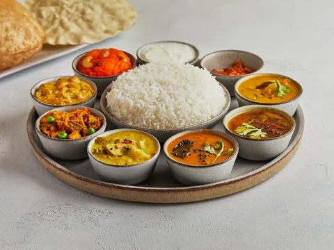 South Indian thali with rice, assorted curries, poori, and papad at Saravanaa Bhavan