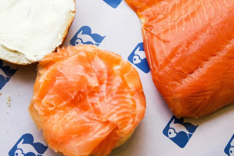 Bagel with cream cheese next to sliced smoked salmon at Russ & Daughters