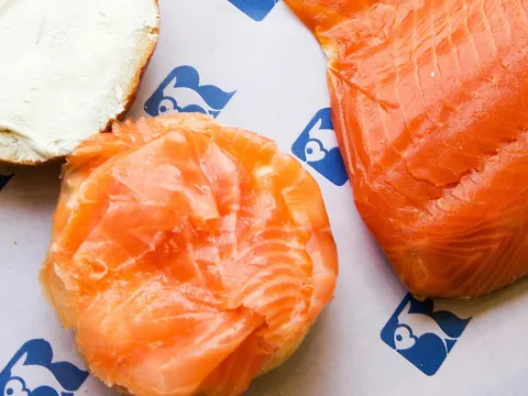 Bagel with cream cheese next to sliced smoked salmon at Russ & Daughters