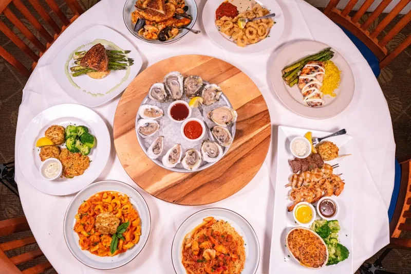 Overhead spread of oysters, seafood entrees and sides at Big Fish Grill on the Riverfront
