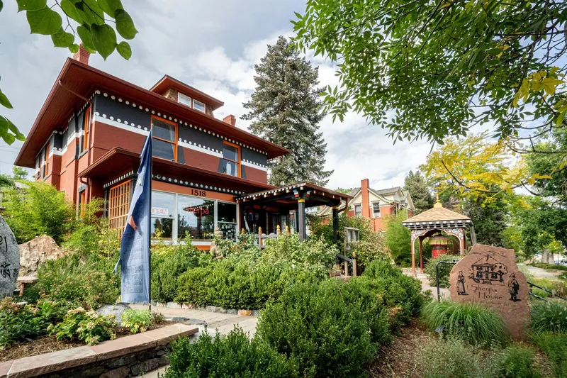 Exterior of Sherpa House Restaurant & Cultural Center with Tibetan-style details and a garden