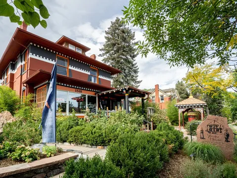 Exterior of Sherpa House Restaurant & Cultural Center with Tibetan-style details and a garden