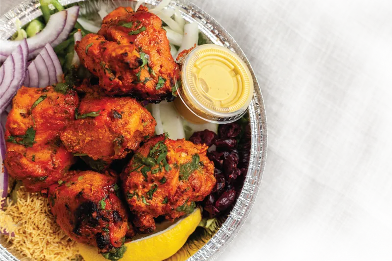 Tandoori chicken platter with rice and pickled onion at Jai Ho Indian Kitchen