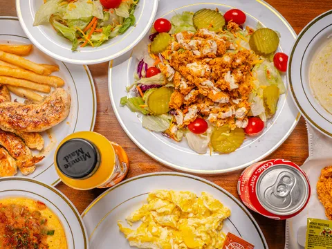 Table of Southern plates including fried chicken, catfish, eggs and grits at Sugar's Place