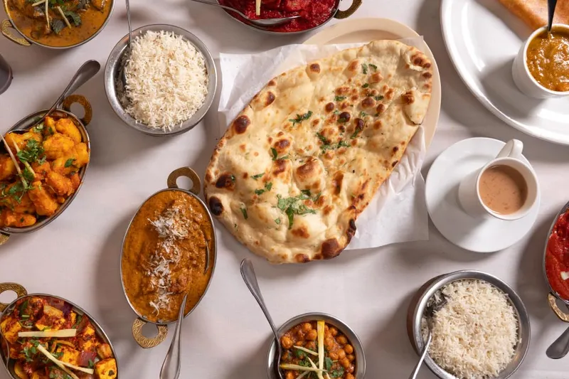 Curries, rice, naan and chai spread across a table at Siri Indian Cuisine