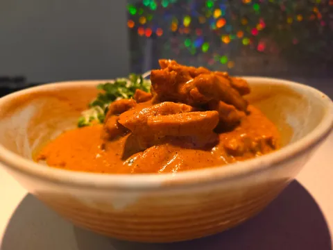 Chicken makhni (butter chicken) in a creamy tomato sauce served in a ceramic bowl at The Blue Taj