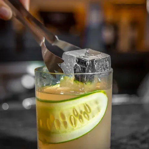 A craft cocktail with cucumber garnish at STIR