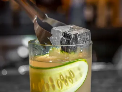 A craft cocktail with cucumber garnish at STIR