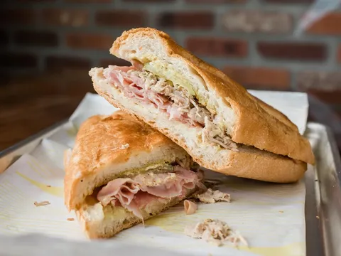 A sliced Cuban sandwich with ham, roast pork and pickles at La Segunda Central Bakery