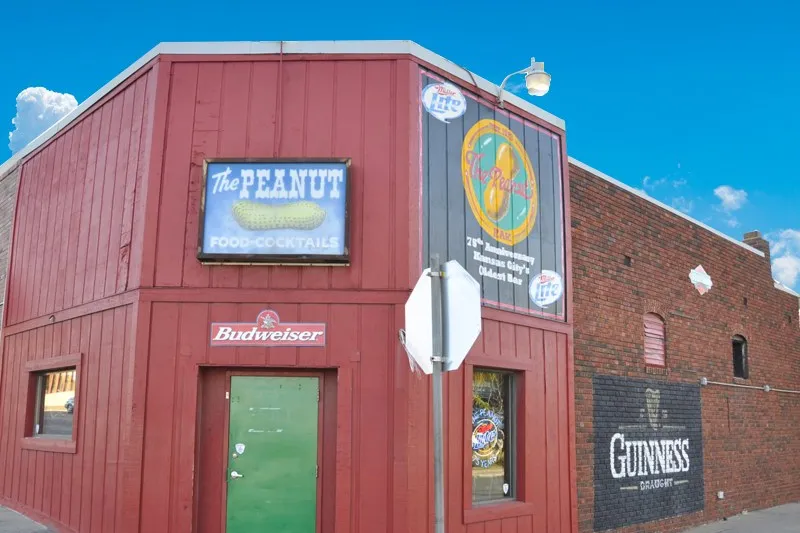 Red-painted corner exterior of The Peanut with its neon sign