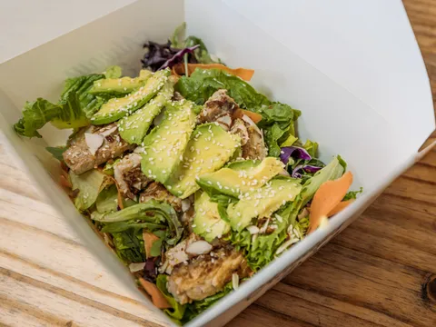 Grilled fish salad with avocado, greens and sesame in a takeout box at Oscar's Mexican Seafood