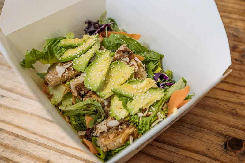Grilled fish salad with avocado, greens and sesame in a takeout box at Oscar's Mexican Seafood