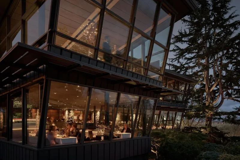 Glass-walled Canlis dining room overlooking Seattle at dusk