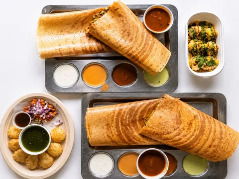 Two dosas on steel trays with sambar, chutneys and chaat at Dosa House in Bellevue.