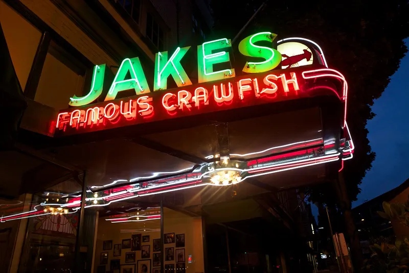 Jake's Famous Crawfish neon storefront sign lit up at night in downtown Portland