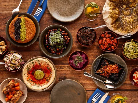 Spread of salatim, hummus, laffa, and lamb shoulder at Zahav