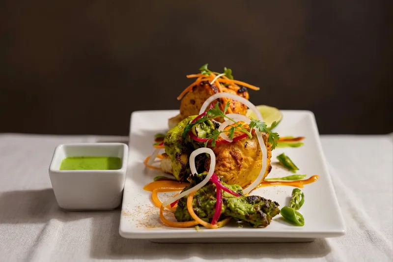 Chicken 65 bezule served in a crispy filo basket with curry leaves, lemon, and red onion at Turmeric in University City
