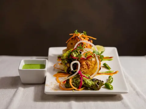 Chicken 65 bezule served in a crispy filo basket with curry leaves, lemon, and red onion at Turmeric in University City