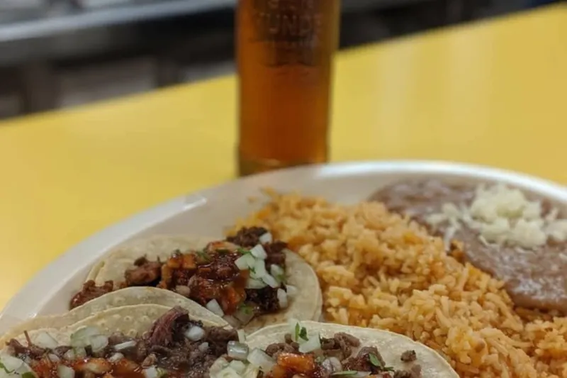 A plate of tacos with rice and beans at El Taco de Mexico
