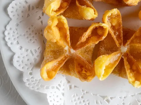 Golden fried crab rangoons on a white plate at Grand Oriental.