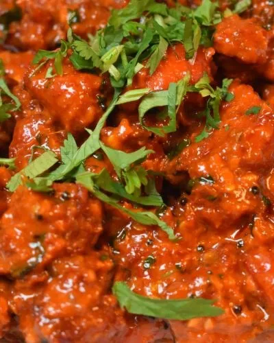 Close-up of a red curry garnished with cilantro at Curry Gate