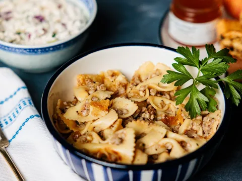 Kasha varnishkes — bow-tie pasta with buckwheat — in a blue-rimmed bowl beside chopped salad and rugelach at Zingerman's Delicatessen
