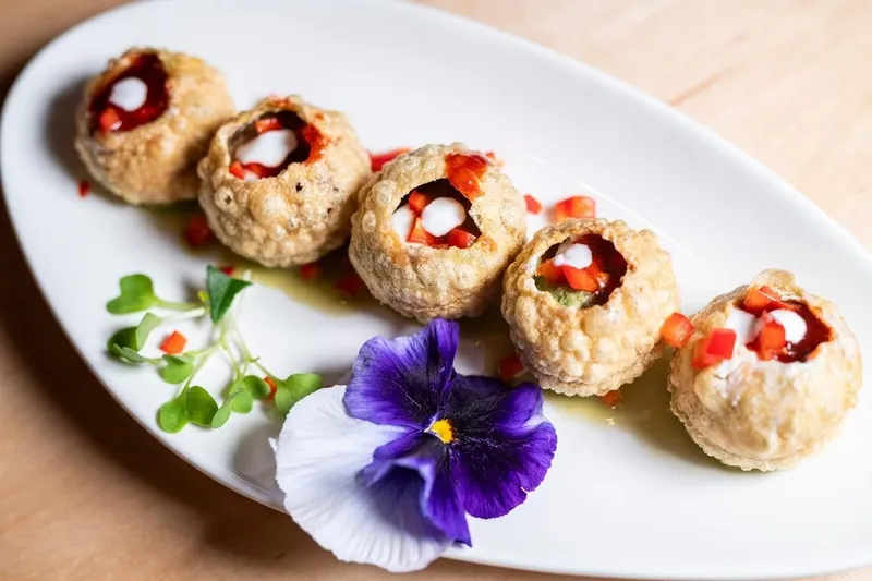 Plated pani puri garnished with a pansy at Turmeric Indian Cafe & Bar
