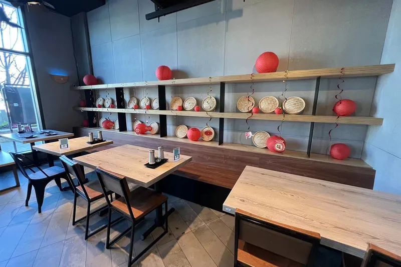 Empty dining room with red lanterns and shelved crockery at Dough Zone