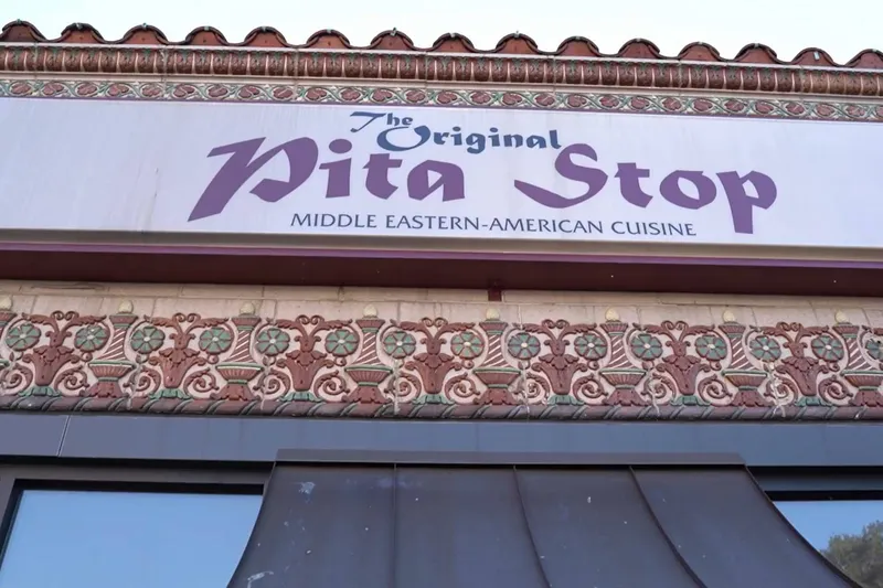 Awning over the entrance of The Original Pita Stop in Birmingham, lettered "Middle Eastern-American Cuisine"