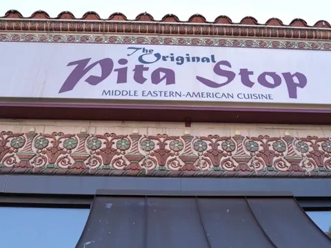 Awning over the entrance of The Original Pita Stop in Birmingham, lettered "Middle Eastern-American Cuisine"
