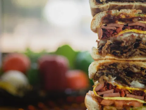 Towering stack of sliced tortas showing layered meats, cheese and vegetables at Los Reyes de la Torta