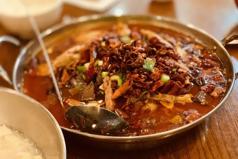 Sichuan boiled dish topped with dried red chilies and scallions in chili oil at Chengdu Taste Las Vegas