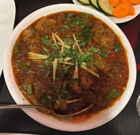 Bowl of chicken kadai garnished with ginger and cilantro at Hyderabad House Family Dining