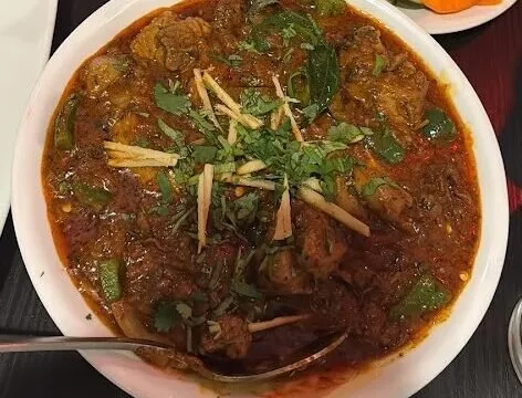 Bowl of chicken kadai garnished with ginger and cilantro at Hyderabad House Family Dining