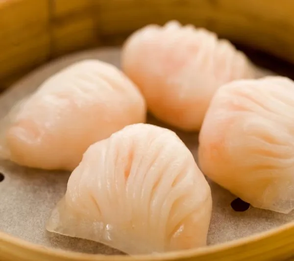 Bamboo steamer of translucent har gow shrimp dumplings at Tim Ho Wan
