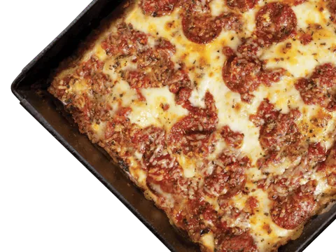 Buddy's Pizza's original Detroit-style square pepperoni pizza with caramelized cheese edges, baked in a seasoned steel pan