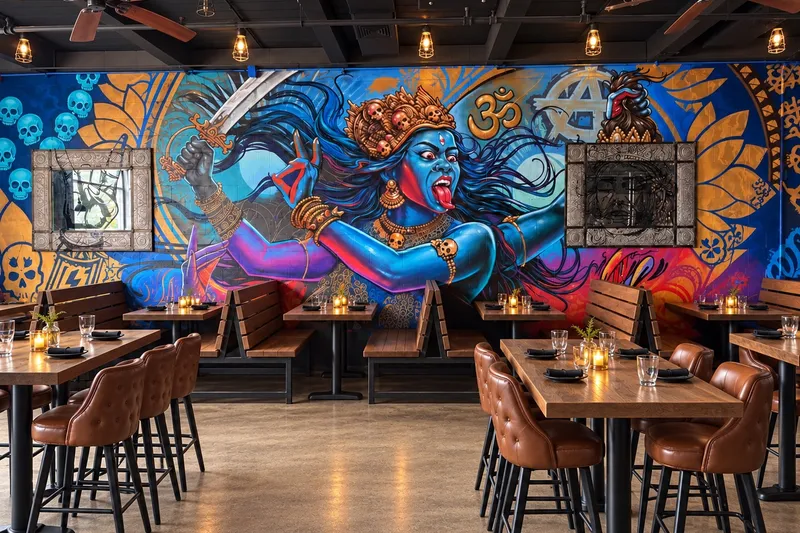 Dining room at Aatma Curry House inside Widowmaker Brewing in Brighton, Boston, with a large blue Kali mural behind wooden tables and leather bar stools