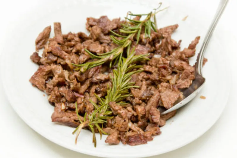 Plate of Meaza beef tibs, sautéed beef cubes garnished with rosemary, at Meaza Restaurant, Falls Church VA