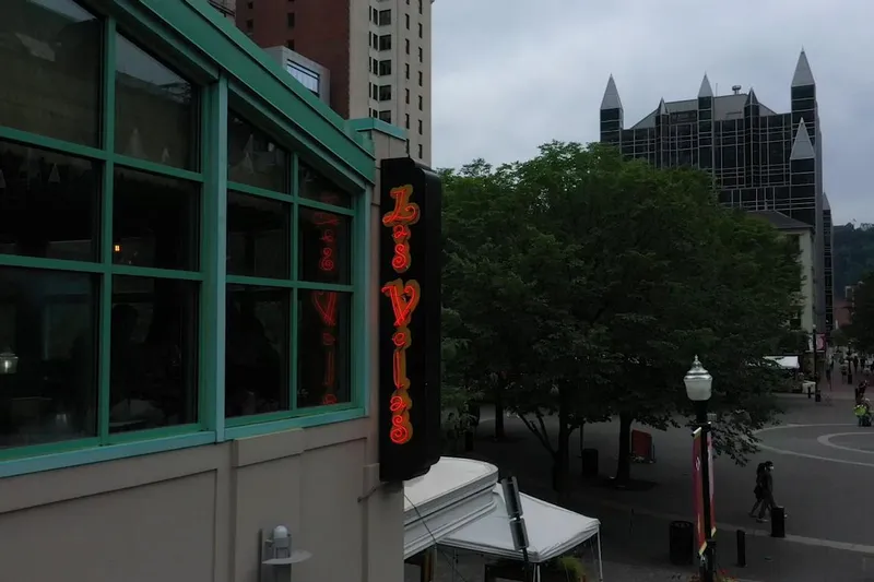 The vertical red neon "Las Velas" sign on the restaurant's Market Square frontage in downtown Pittsburgh