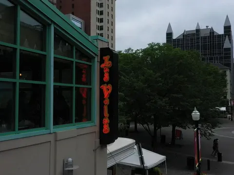 The vertical red neon "Las Velas" sign on the restaurant's Market Square frontage in downtown Pittsburgh