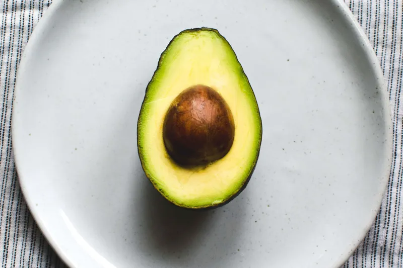 A halved avocado on a plate at ā café