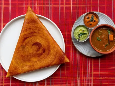 Triangular gunpowder dosa served with sambar and chutneys at Semma