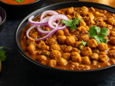 A bowl of chana masala topped with onions and cilantro from Curry Nation.