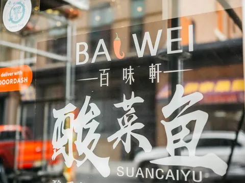 Bai Wei storefront window decal in Philadelphia Chinatown showing the restaurant's name and 百味軒 with a Sichuan suancaiyu (pickled cabbage fish) illustration