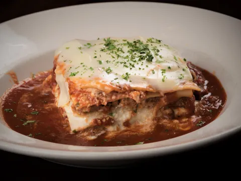 Baked lasagna layered with Italian sausage, beef and ricotta topped with provolone in Maggie's sugo at Garozzo's Ristorante