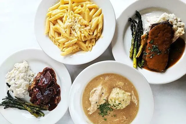 Overhead view of Mother's Bistro & Bar signature dishes including macaroni, pot roast, meatloaf, and chicken & dumplings