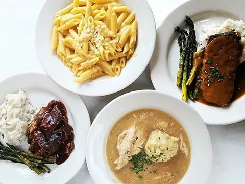 Overhead view of Mother's Bistro & Bar signature dishes including macaroni, pot roast, meatloaf, and chicken & dumplings